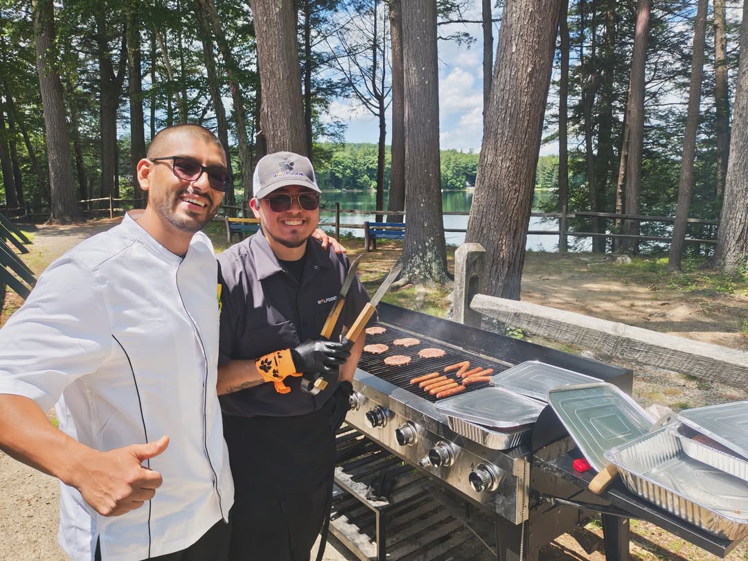 WOLFoods team cooking outdoors by a lake