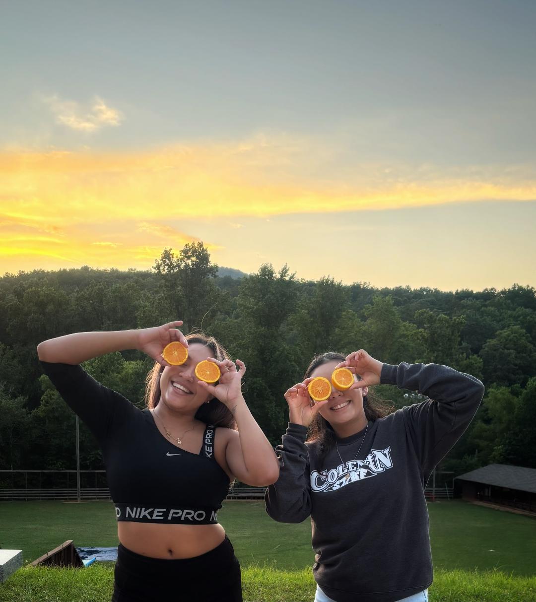 Team members holding oranges at camp